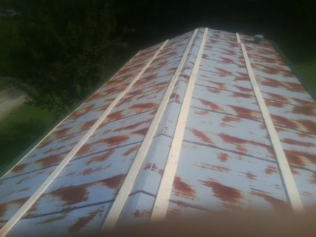 Rusted metal roof panels with new wood purlins before replacement — Storm Damage Roof Repair in Starrucca by Roofing Brothers