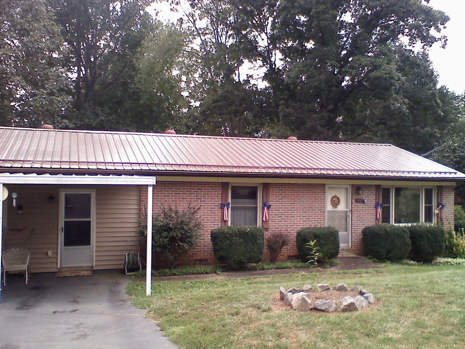 Bronze metal roof and carport on a brick ranch home — Roof Repair work by our crew in Starrucca